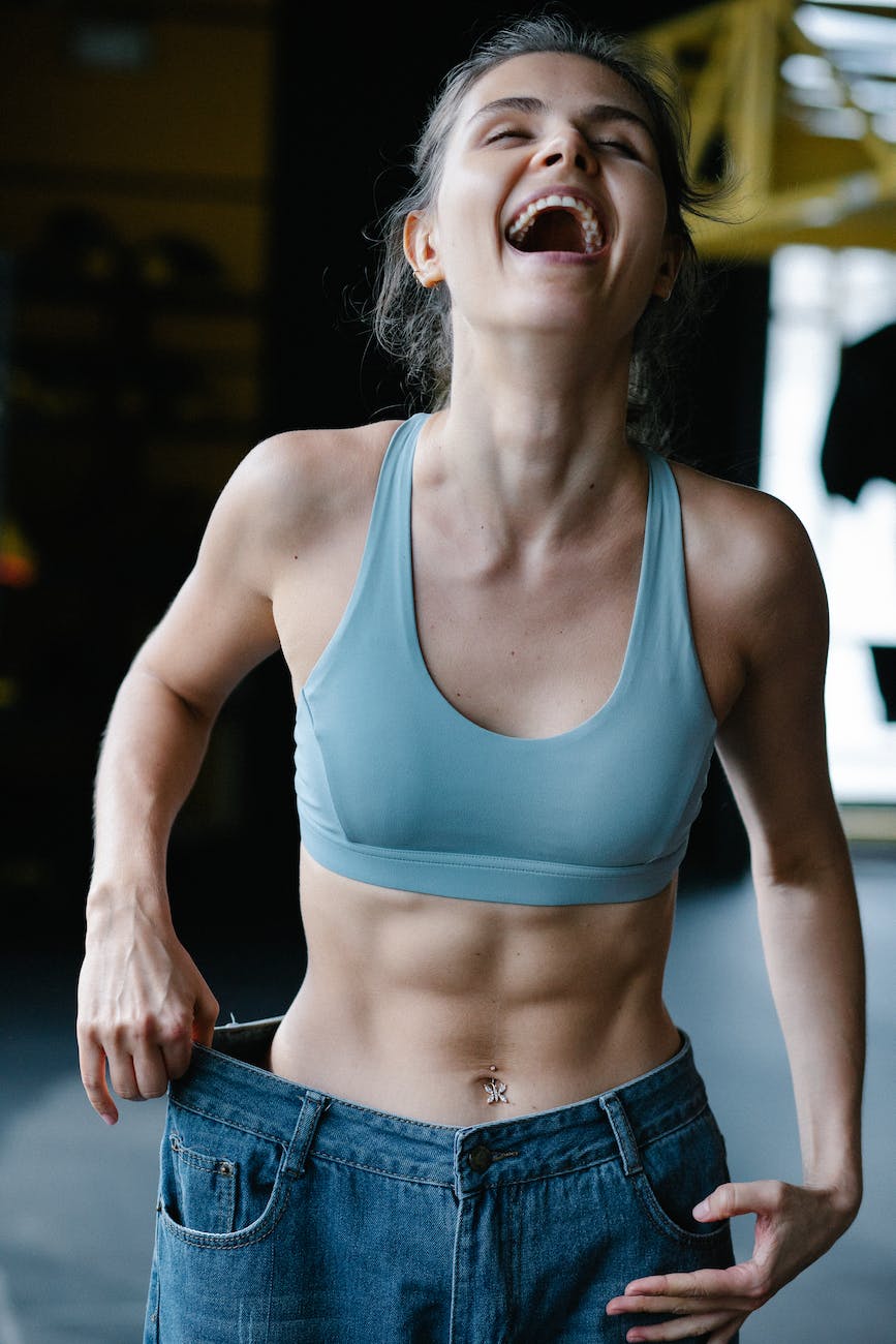 smiling fit woman wearing too big jeans